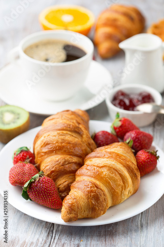 Continental breakfast table with coffee, orange juice, croissants