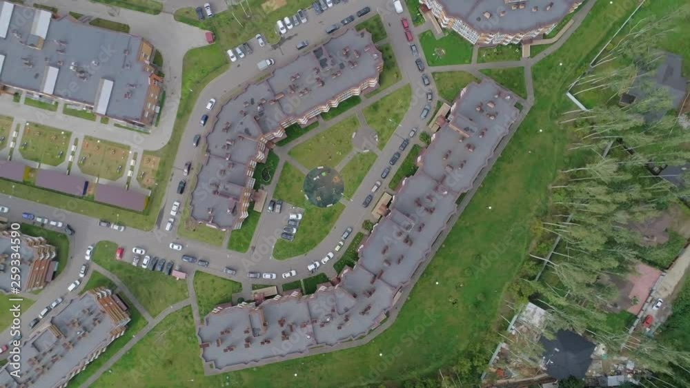 Shooting a residential area with low-rise buildings, roads on which cars go, aerial photography, the camera moves away from the object on a summer day Shooting a residential area with low-rise buildings, roads on which cars go, aerial photography, the camera moves away from the object on a summer day