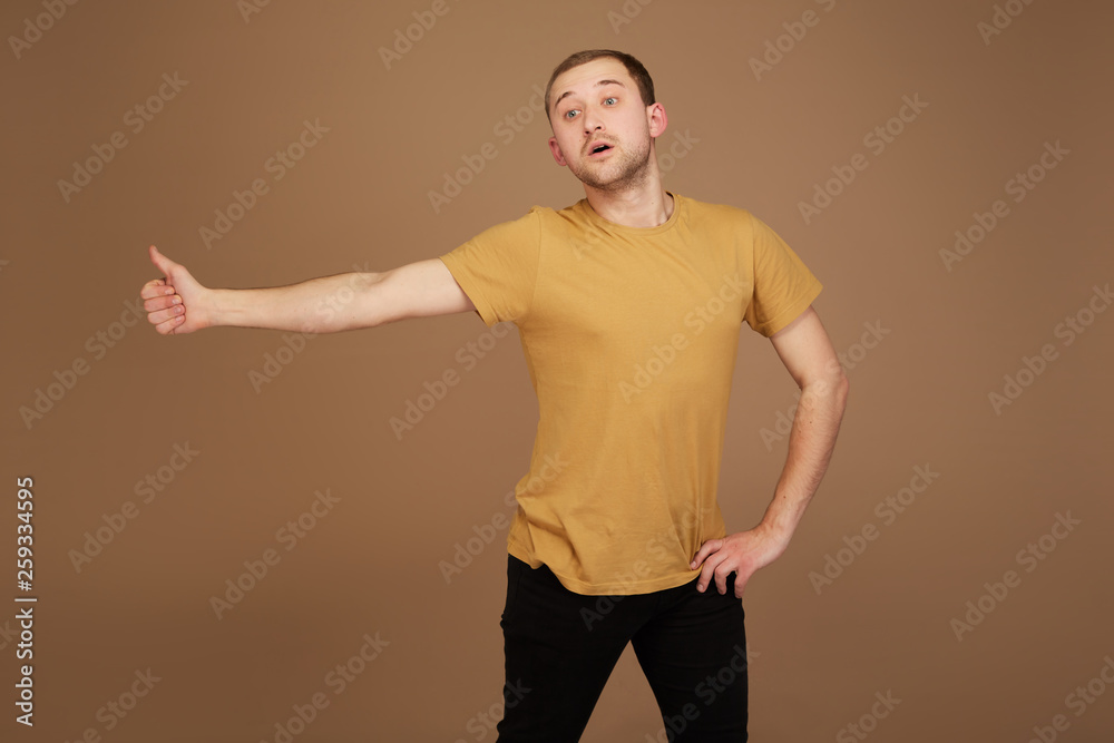 young man in yellow shirt shows a finger up like young man in yellow shirt shows a finger up like