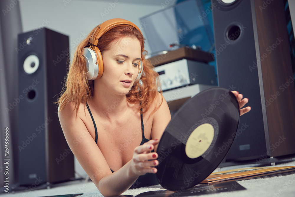 Fototapeta premium the image of resting sexy woman listening to vinyl