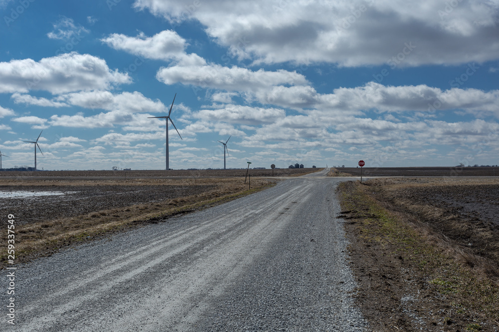 Old dirt country road in the middle of midwestern farm country with epic clouds