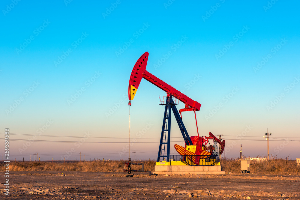 Oil pumps are running in the sunset at the oil field. Oil pumps are running in the sunset at the oil field.