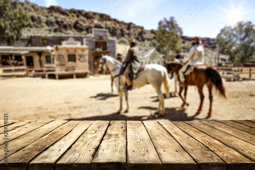 Wooden old table of free space for your product. Blurred background of Wild West city in America. 