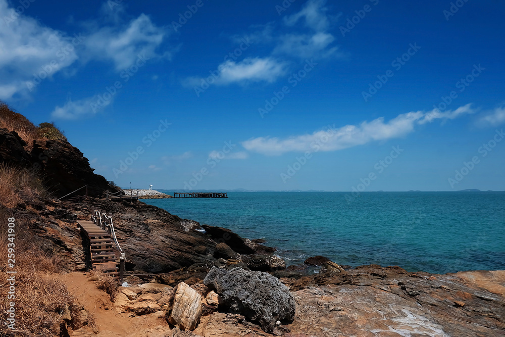 wooden bridge walkway along the rocks coast and sea with blue sky summer time with day light background