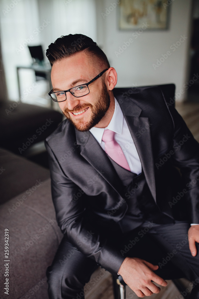 Portrait of a handsome groom in a grey suit with a tie. Portrait of a handsome groom in a grey suit with a tie.