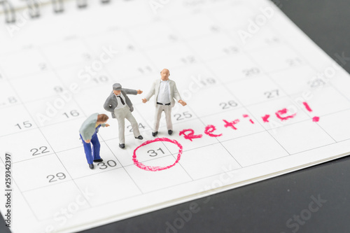 Happy retirement, wealth plan for life after retire from work concept, group of miniature happy senior old men standing with circle on white calendar with handwriting the word retire © Nuthawut