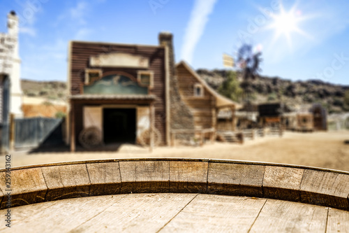 Wooden old table of free space for your product. Blurred background of Wild West city in America. 