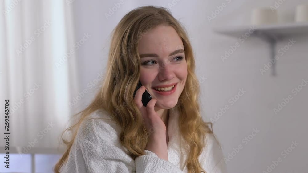 Smiling lady in hotel room talking phone with boyfriend, distance relationship Smiling lady in hotel room talking phone with boyfriend, distance relationship