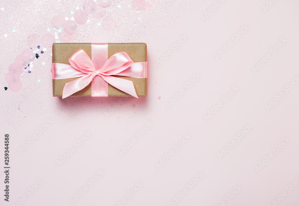 Gift box and Pink confetti and stars and sparkles on pink background. Top view, flat lay. Bright and festive holiday background. For Christmas, New year, Mother's day, International woman's day Gift box and Pink confetti and stars and sparkles on pink background. Top view, flat lay. Bright and festive holiday background. For Christmas, New year, Mother's day, International woman's day