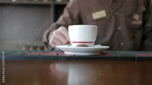 Barista made coffee and serves it to the bar. Background cup of coffee on a bar