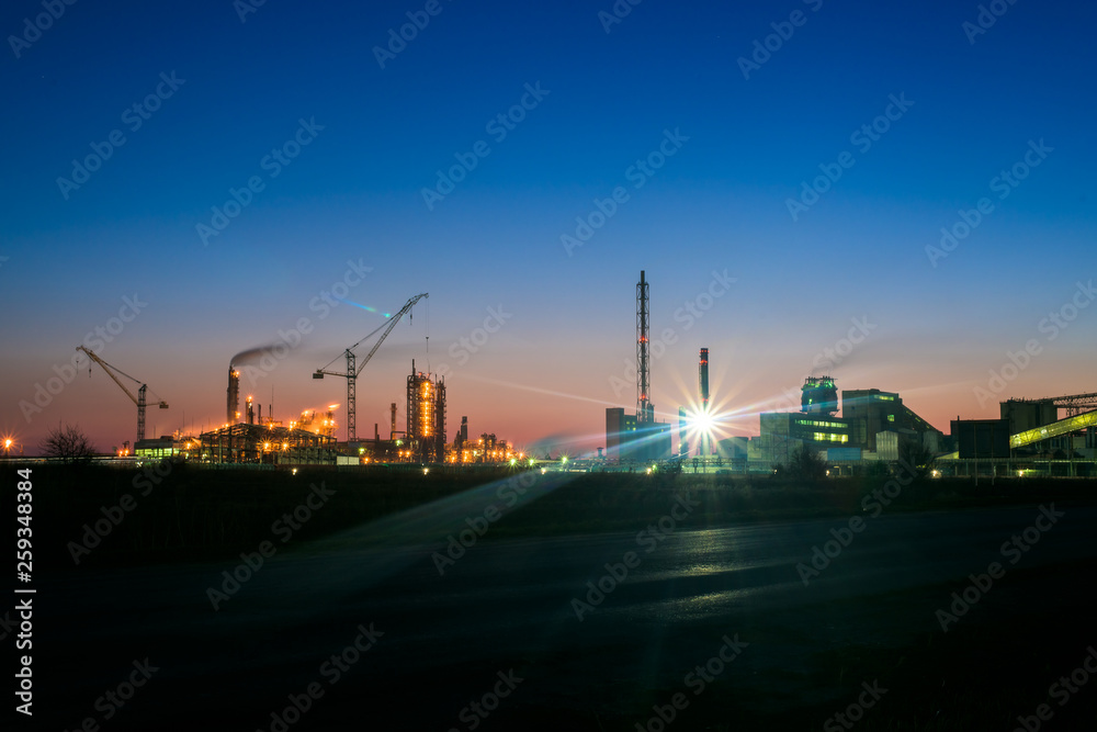 chemical plant in a silhouette image at sunset, the glowing light of the chemical industry at sunset and twilight sky, the field of chemistry