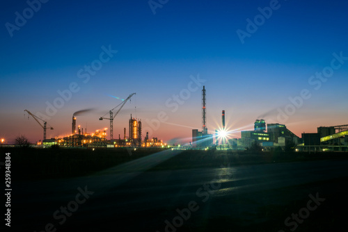 chemical plant in a silhouette image at sunset, the glowing light of the chemical industry at sunset and twilight sky, the field of chemistry