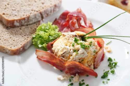 Scrambled eggs with chives and fried bacon.