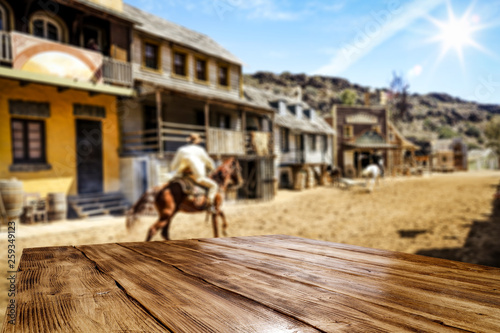 Wooden old table of free space for your decoration and Wild West background. 