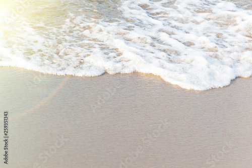 Soft wave of ocean on sandy beach. Nature background. Flat lay concept. Place for your text.