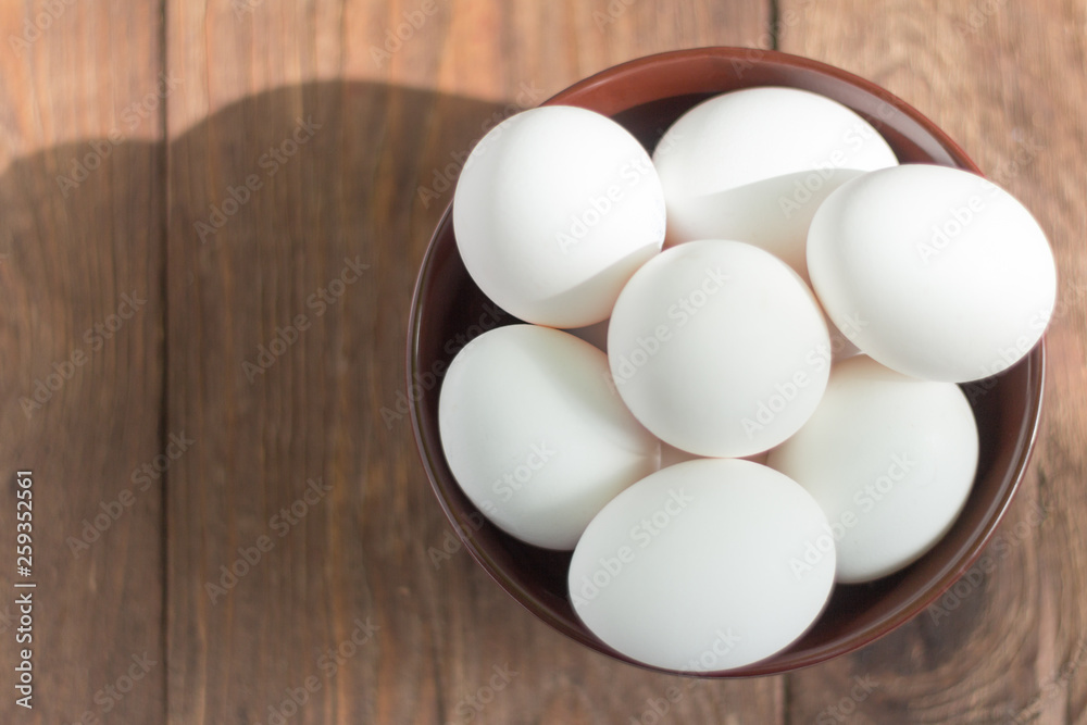 white chicken eggs in bowl on wooden background white chicken eggs in bowl on wooden background