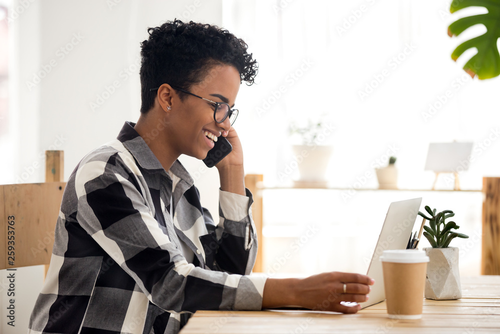 Smiling woman working using computer and phone in office Smiling woman working using computer and phone in office