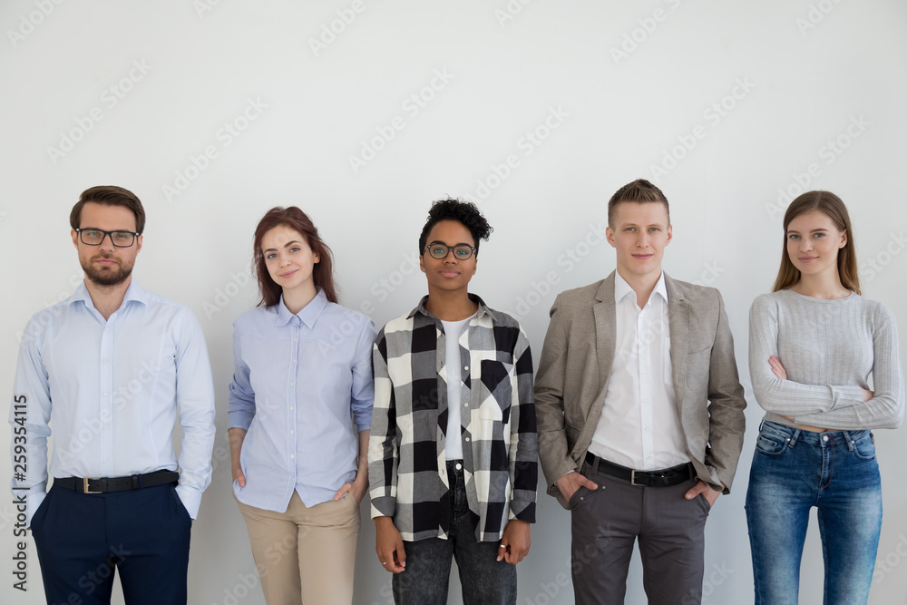 Group of young business people standing looking at camera Group of young business people standing looking at camera