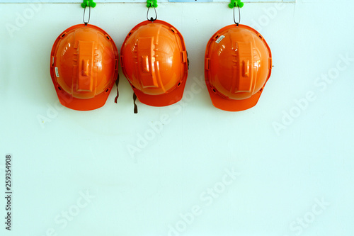 orange safety hat hanging on wall at the factory