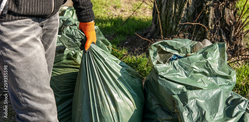 Hand man picking up trash cleaning in the street , volunteer concept