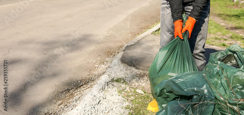 Hand man picking up trash cleaning in the street , volunteer concept
