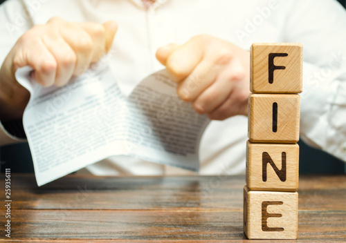 A person disputed the illegal fines and taxes. Unfair tariffs and penalties. Proof of innocence and exemption from payment. Categorical disagreement with traffic violation charges. Wooden blocks photo