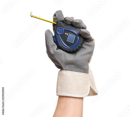 Close up view of Worker Man Hand holding Tape-measure. Male Hand wearing Working Glove with Tools. Human hand, isolated on white background. © DenisNata
