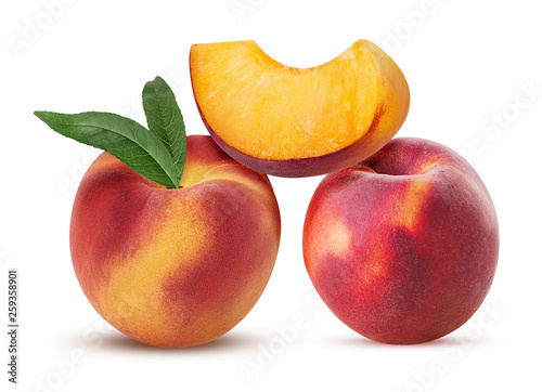 Two ripe peach fruit with leaf and slice