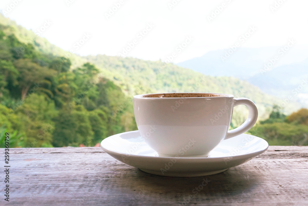 White coffee cup on wood table with background landspace mountain