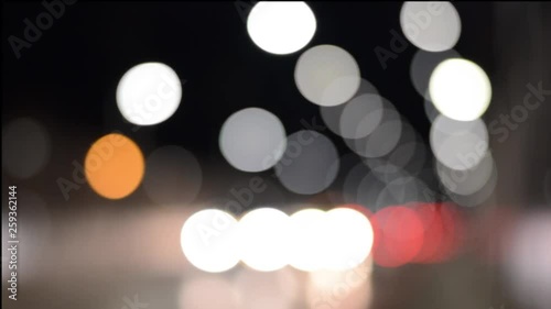 Blurred background of city street lights and moving vehicles during the night.