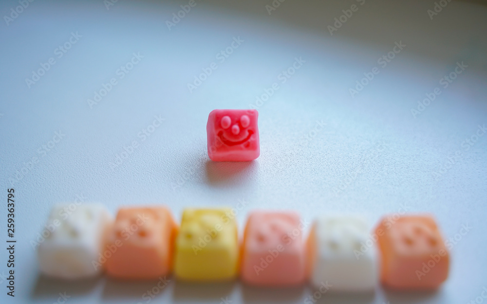 delicious square bright candy with smile on white background delicious square bright candy with smile on white background