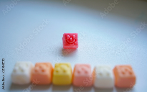 delicious square bright candy with smile on white background