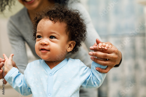 Mixed race mother playing with baby son in living room