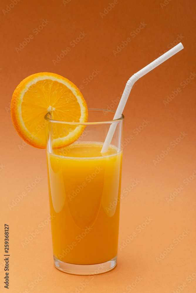 a glass of orange juice on an orange background with a straw and a slice of orange a glass of orange juice on an orange background with a straw and a slice of orange