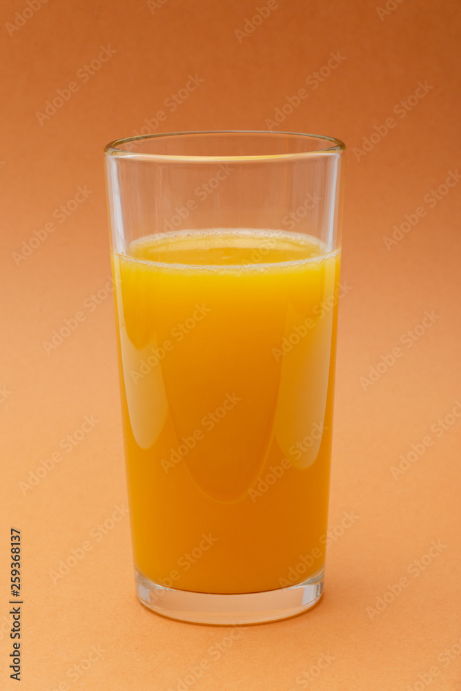 glass of orange juice on an orange background glass of orange juice on an orange background