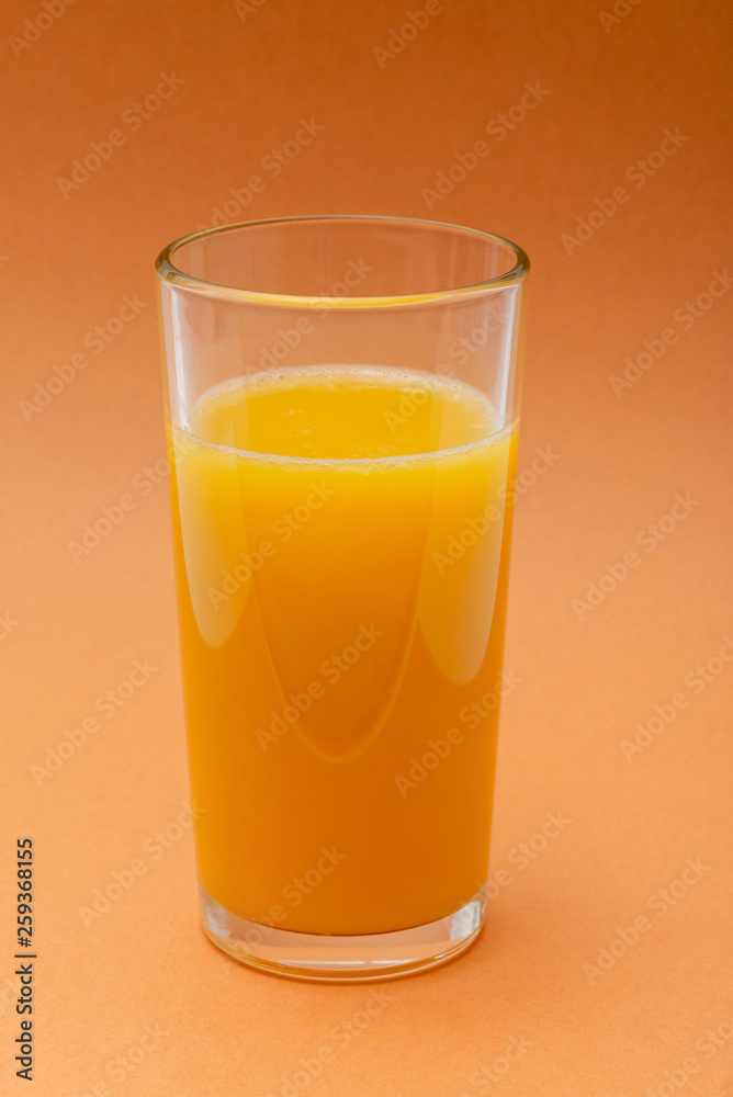 glass of orange juice on an orange background glass of orange juice on an orange background