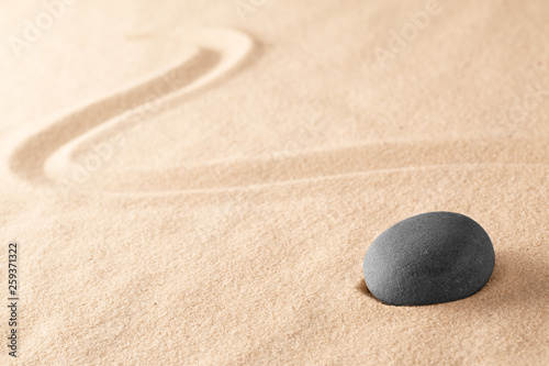black zen meditation stone in Japanese sand garden. Concept for harmony and balance in yoga and mindfulness.