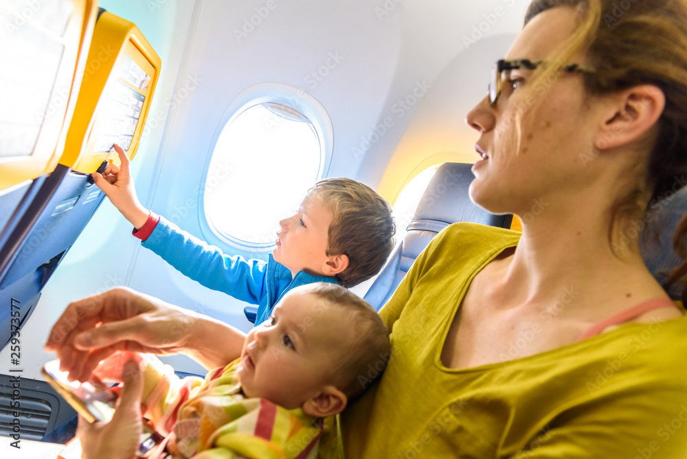 Obraz premium Family of mother, child and baby traveling sitting in the seats of an airplane.