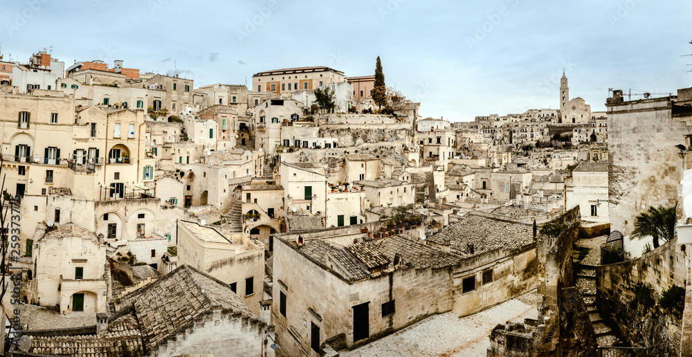 Panoramic view of Matera (Sassi di Matera) with its steep ancient stone streets, European Capital of Culture 2019, with clouds, at southern Italy, waiting to welcome tourists.