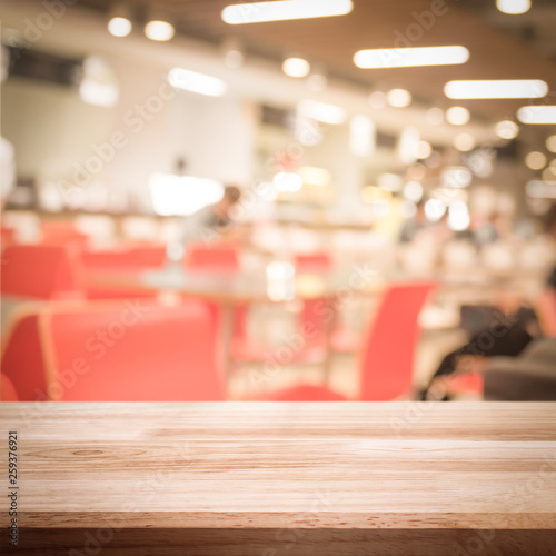 empty brown wooden table and restaurant blurred background with bokeh image, for product display montage. Selected focus