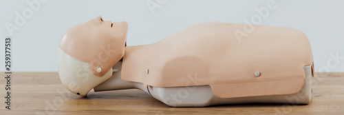 Φωτογραφία panoramic shot of cpr dummy for first aid training on wooden table