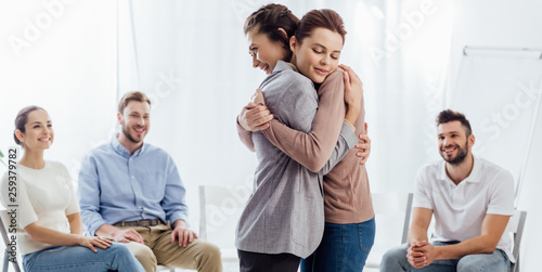 Φωτογραφία panoramic shot of women hugging during group therapy session