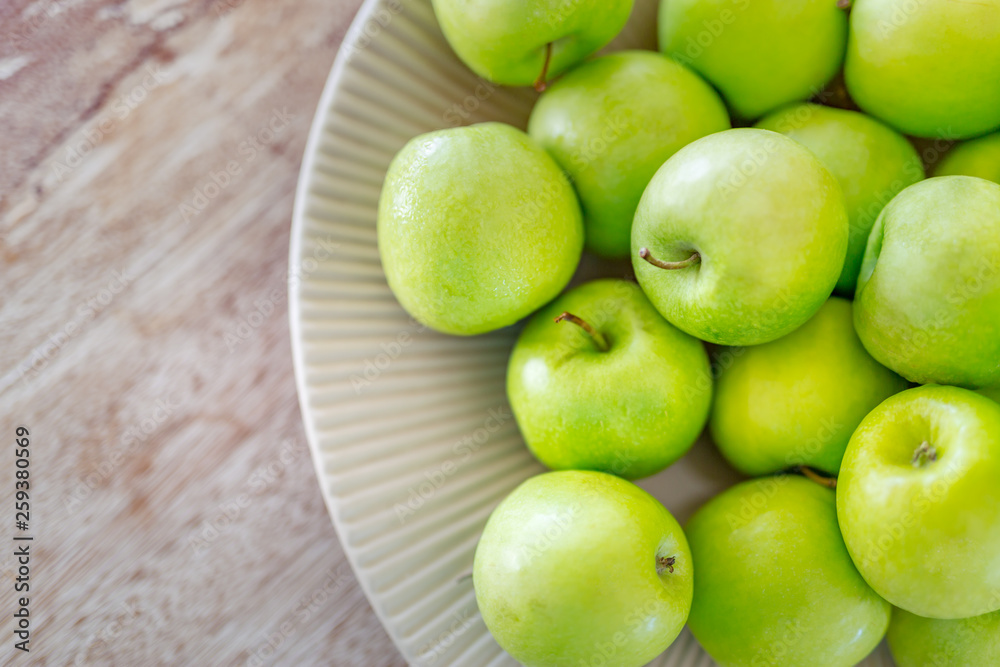 Fresh green apples in bowl on wooden background Fresh green apples in bowl on wooden background