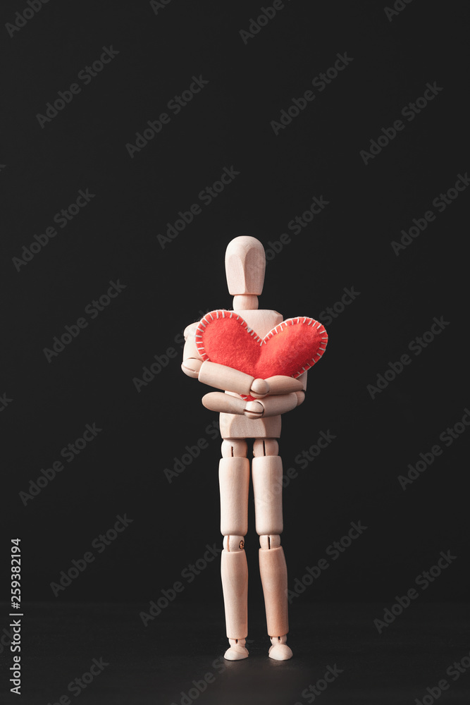 Warm feeling. Lonely yet caring. Love cherish and protection. Conceptual articulated mannequin composition. Red heart. Warm feeling. Lonely yet caring. Love cherish and protection. Conceptual articulated mannequin composition. Red heart.