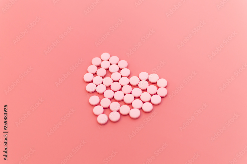 Pink pills and thermometer in shape of heart on pink background. Pharmaceutical, medicine, health care creative concept. Selective focus composition for medical topics design Pink pills and thermometer in shape of heart on pink background. Pharmaceutical, medicine, health care creative concept. Selective focus composition for medical topics design