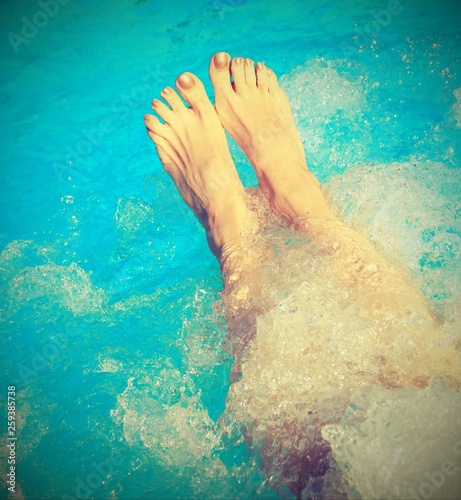 legs of a young woman who relaxes in the hot tub of the spa with