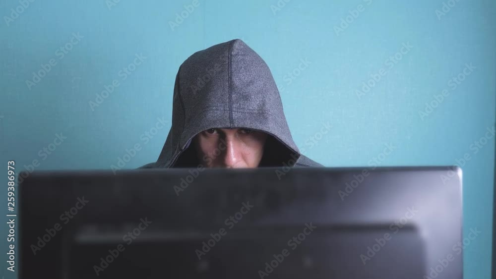 man hacker in the hood hacking network concept. unknown hacker criminal breaks into computer protection on the Internet passwords. lifestyle male hacker penetrates into hack network protection web man hacker in the hood hacking network concept. unknown hacker criminal breaks into computer protection on the Internet passwords. lifestyle male hacker penetrates into hack network protection web