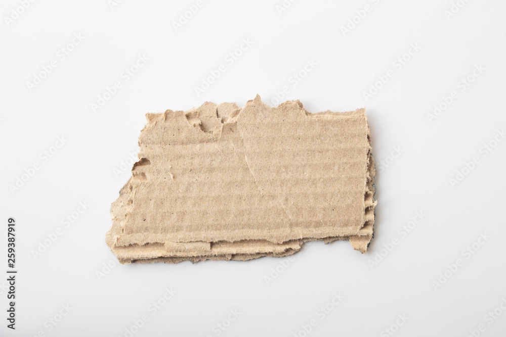 Brown corrugated texture paper torn on white background. rip of cardboard sheet used as a background .