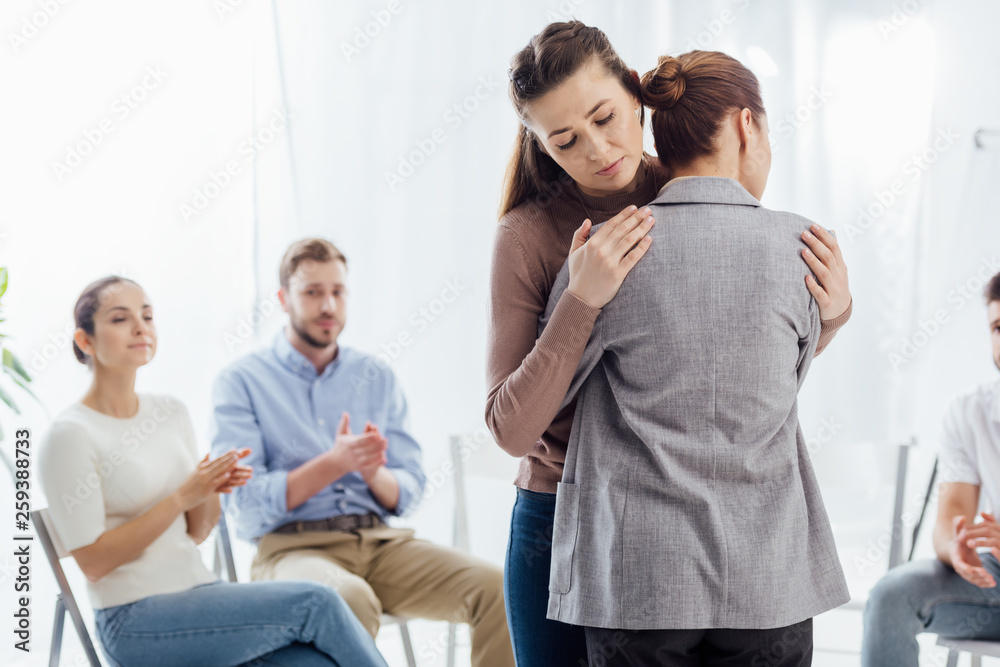 Obraz premium selective focus of women hugging during group therapy session