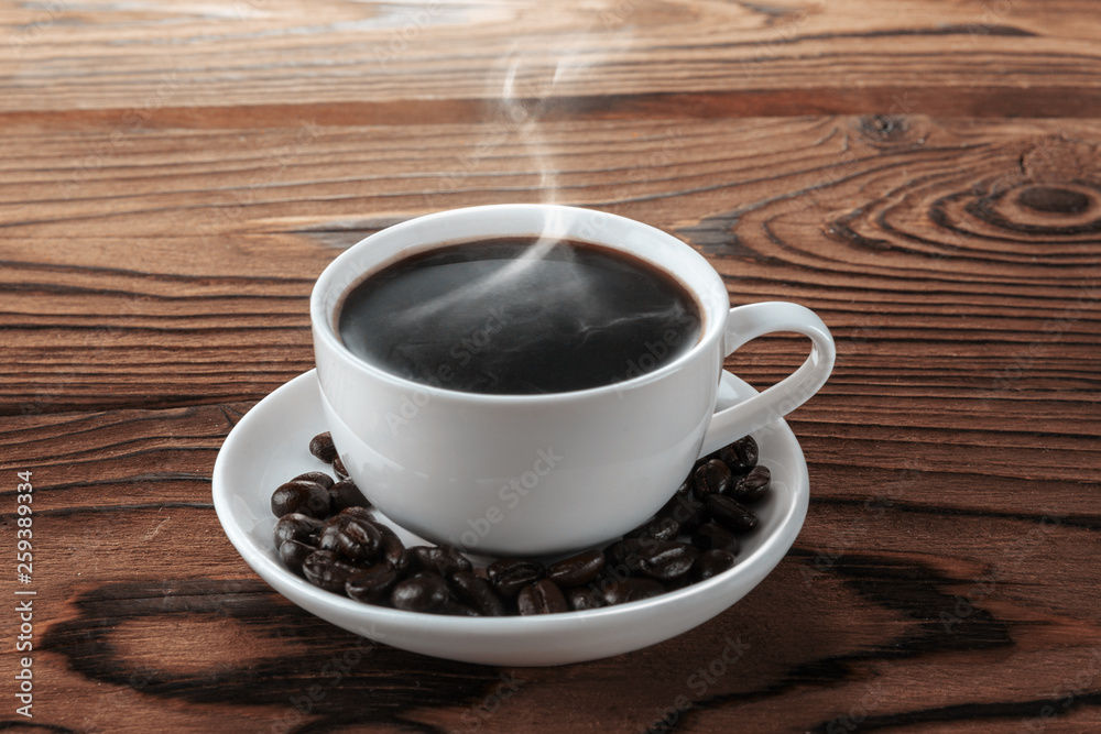 Chocolate with hot steam and coffee beans on wooden table Chocolate with hot steam and coffee beans on wooden table